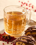 Harvest Moon Pumpkin Spice Chai brewed in a glass mug with pumpkin cookies, included in the Holiday Tea Bundle