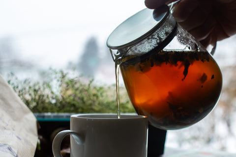 Panda Ruby Red tea leaves from Lake Missoula Tea Company, shown in a winter garden setting with fresh tea product.