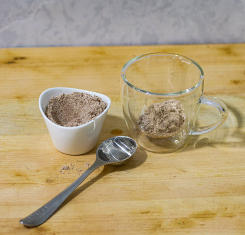 Cup of Lake Missoula Tea Company's INSTANT Chai tea with frothy milk, served in a white ceramic mug on a wooden surface.