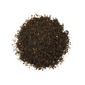 Lake Missoula Tea Company's High Country Huckleberry tea in a teacup with fresh huckleberries and tea leaves, highlighting the flavor.