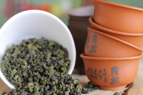 Lake Missoula Gunpowder Pearls tea displayed in a clear glass container with loose green tea leaves and pearls.