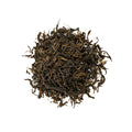 Green Puerh tea from Lake Missoula Tea Company, showing fresh green tea leaves in a natural setting.