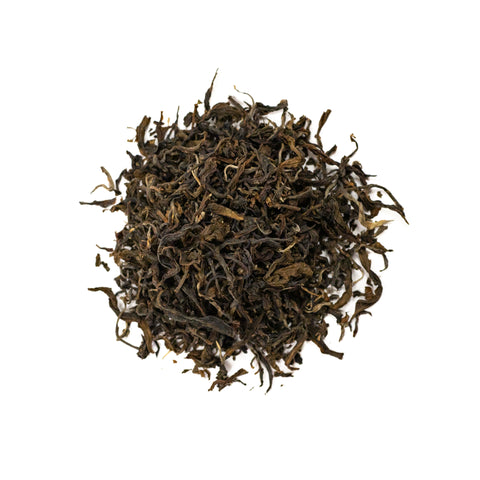 Green Puerh tea from Lake Missoula Tea Company, showing fresh green tea leaves in a natural setting.