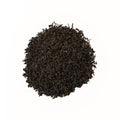 Brewed Lapsang Souchong tea in a clear glass cup, showcasing its dark amber color, from Lake Missoula Tea Company.