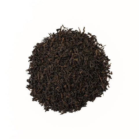 Brewed Lapsang Souchong tea in a clear glass cup, showcasing its dark amber color, from Lake Missoula Tea Company.