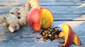 Cup of Ginger Peach Sunshine Daydream tea from Lake Missoula Tea Company with fresh ginger and peach slices.