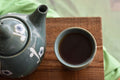 Dark Chocolate Mint Puerh tea in a green and white cup, showcasing the Lake Missoula Tea Company blend.