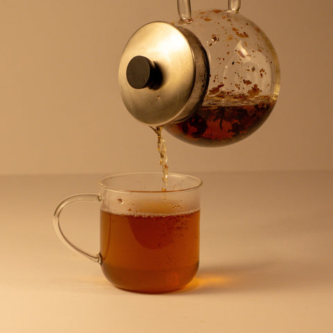 Rose Chai tea by Lake Missoula Tea Company in a steaming cup with rose petals and spices, showcasing a warm and aromatic beverage.
