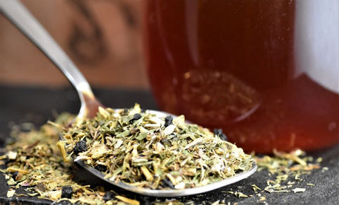 Cup of No Thyme for Cold & Flu herbal tea by Lake Missoula Tea Company in a mug with fresh thyme sprigs and lemon slices.