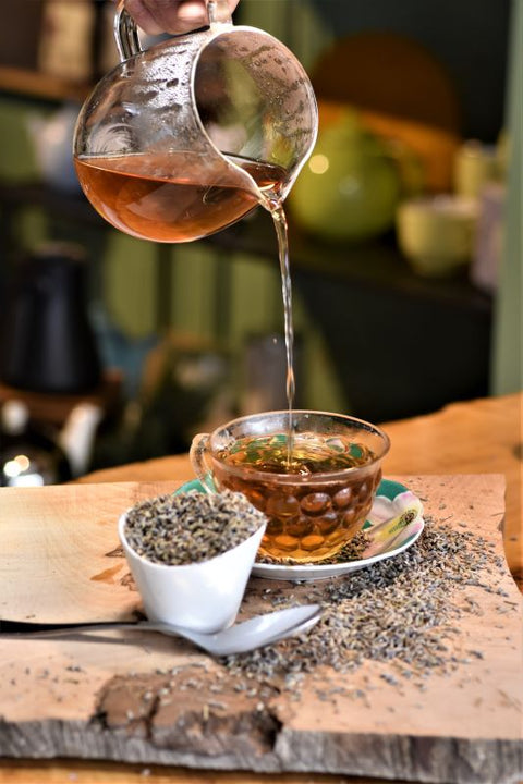 Lavender Lift tea from Lake Missoula Tea Company being poured from a glass carafe, showcasing its calming lavender flavor.
