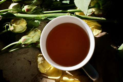 Dried Lapsang Souchong tea leaves in a wooden cup, showcasing the traditional smoked tea from Lake Missoula Tea Company.