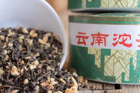 Ginger Orange Puerh tea in a cup, featuring vibrant orange slices and fresh ginger slices from Lake Missoula Tea Company.