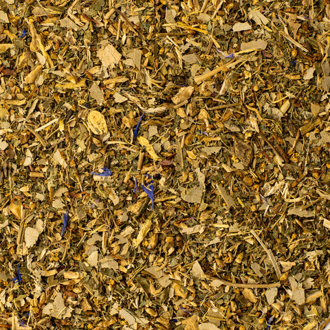 Relaxing Zen Cleanse tea from Lake Missoula Tea Company in a clear glass cup with fresh herbs and tea leaves.