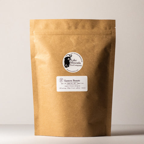 Dried Eastern Beauty tea leaves from Lake Missoula Tea Company in a 500g package, showcasing whole, twisted green tea leaves.