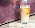 Glass of Lake Missoula Thai Cardamom Tea being poured, showcasing the fragrant, spiced tea aroma and vibrant amber color.