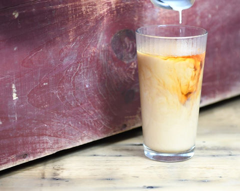 Glass of Lake Missoula Thai Cardamom Tea being poured, showcasing the fragrant, spiced tea aroma and vibrant amber color.