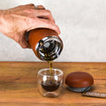 Fellow Carter Color Move Mug from Lake Missoula Tea Company pouring tea into a glass cup, showcasing teaware design and vibrant color.