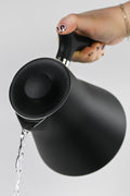 Fellow Corvo black electric water heater kettle pouring hot water, designed for tea brewing, from Lake Missoula Tea Company.
