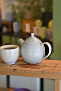 Lake Missoula Tea Company For Life Dew ceramic teapot with matching cup, natural cotton fabric accents, stylish teaware set