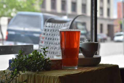 Chilled glass of Sassy Citrus & Spice tea by Lake Missoula Tea Company with fresh citrus slices on a window ledge
