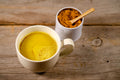 Golden milk tea in a cup, featuring vibrant yellow color with a sprinkle of turmeric on top, from Lake Missoula Tea Company.