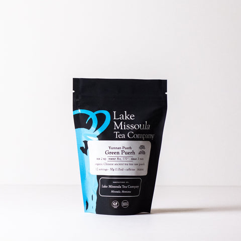Green Puerh tea from Lake Missoula Tea Company in a 2oz package, showing loose green tea leaves with a rich, vibrant appearance.