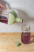 Hario Ka-Ku Cold Brew tea bottle pouring brewed tea into a mason jar, featuring glass teaware from Lake Missoula Tea Company.