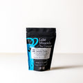Dried jasmine-puerh tea leaves from Lake Missoula Tea Company in a 2 oz package, showcasing fragrant, rolled tea leaves.