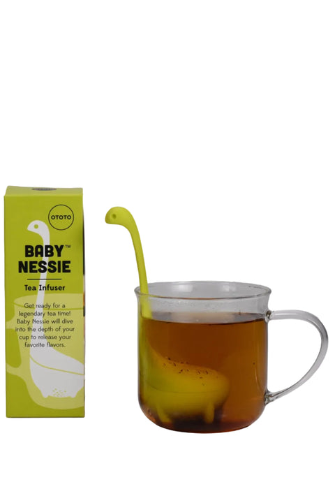 OTOTO Baby Nessie loose leaf tea infuser in lime green, shown with packaging box and lime green infuser steeping in a glass mug of brewed tea