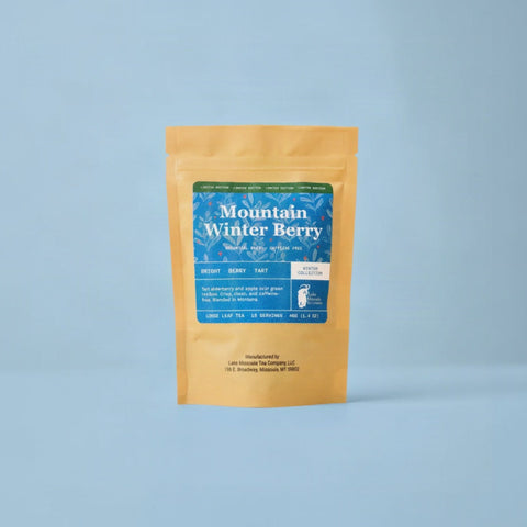 Mountain Winter Berry tea in a kraft pouch with a blue label on a light blue background