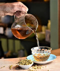 Pouring chamomile calm tea from Lake Missoula Tea Company into a cup, showcasing a relaxing herbal tea beverage.