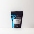 Fresh rose Puerh tea from Lake Missoula Tea Company, loose leaf in a 2oz package, showcasing dark tea leaves with rose petals.