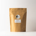 Loose Rose Puerh tea leaves in a clear jar, showcasing the rich, dark tea with rose flower pieces from Lake Missoula Tea Company.