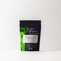 Green tropical fruit tea from Lake Missoula Tea Company, showing fresh green tea leaves and colorful dried fruit pieces.
